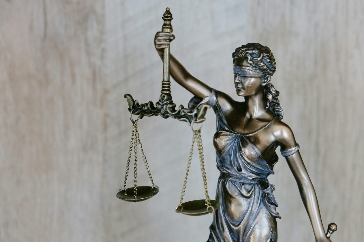 Estátua da justiça segurando uma balança, em close.