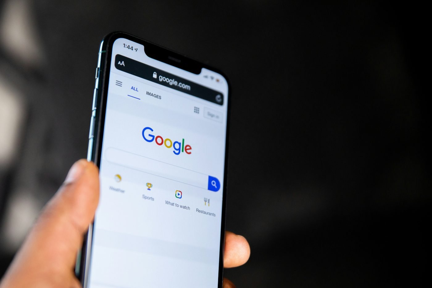Pessoa segurando um celular com a página de busca do Google aberta.