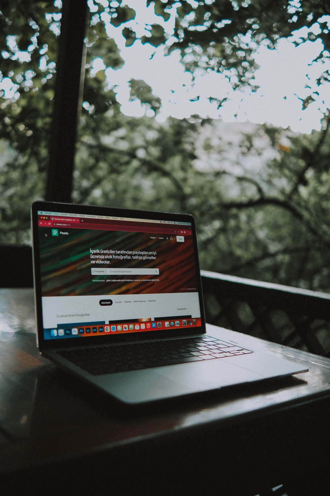 Notebook aberto sobre uma mesa ao ar livre, com um site na tela.